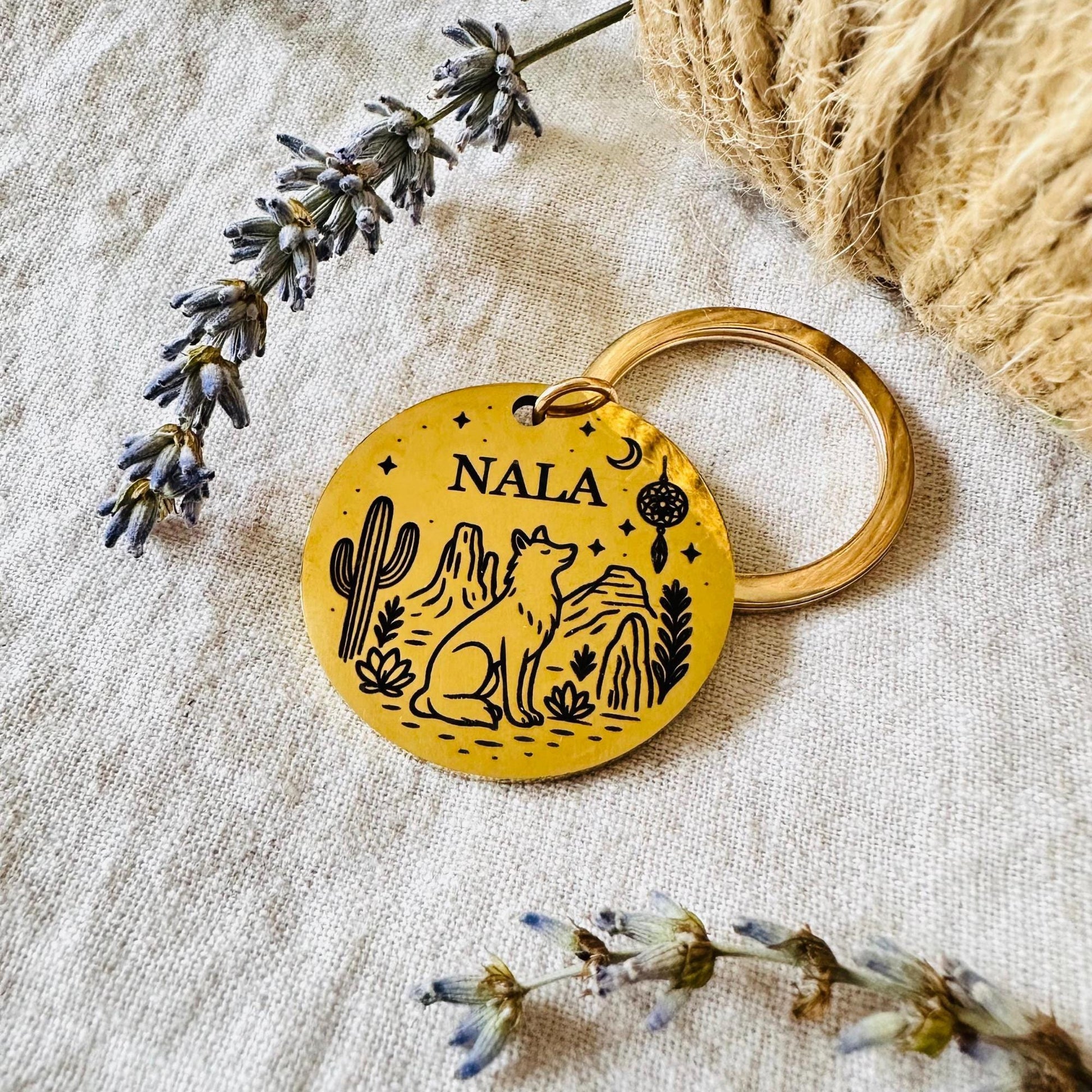 Keychain with 'NALA' engraving on a textured surface with lavender and twine.