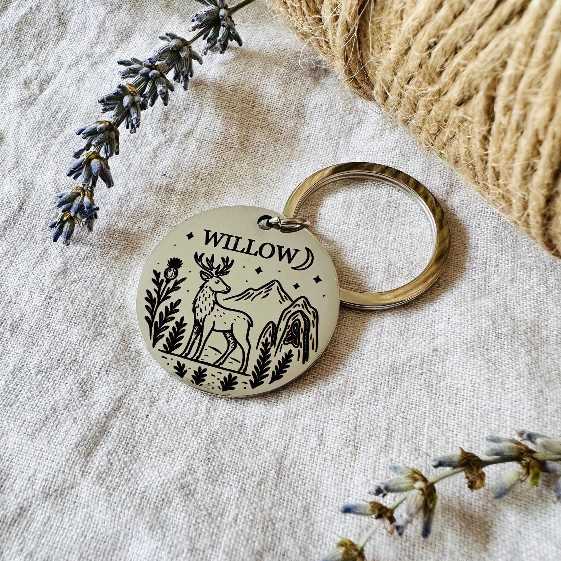 Dog Tag with deer design and 'Willow' text on a textured surface with lavender.