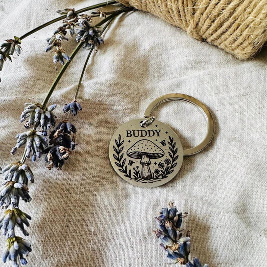 Pet ID tag with mushroom design on a textured fabric background