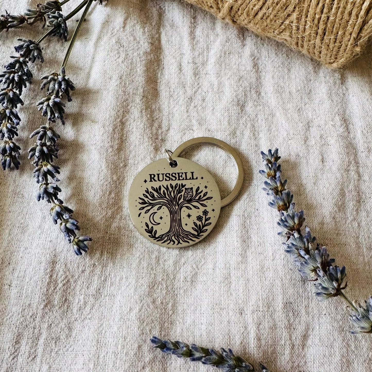 Personalized keychain with engraved design on a textured fabric background with lavender.