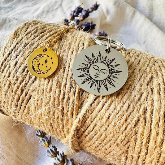 A Dog chain and necklace shaped like a sun and moon on a roll of twine with lavender flowers.