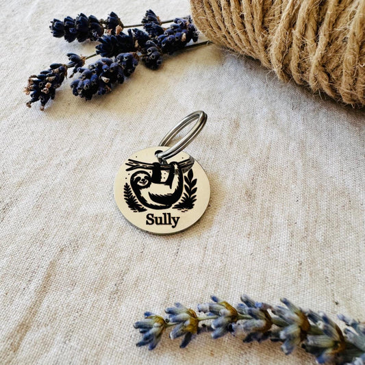 Personalized dog tag with 'Sully' on a textured surface with lavender and twine.